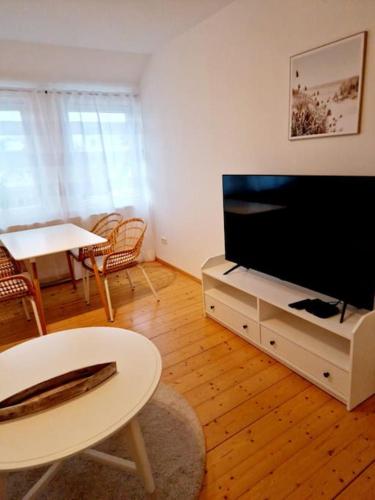 een woonkamer met een flatscreen-tv en een tafel bij Zum Jakobi 6 in Goslar