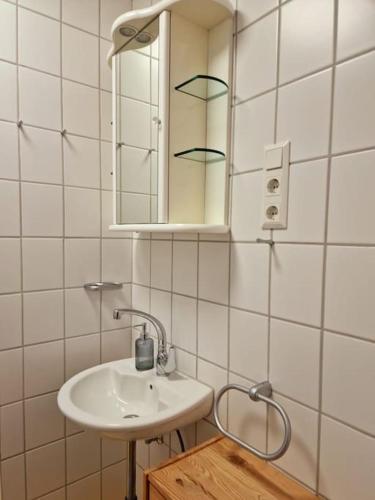 een witte badkamer met een wastafel en een spiegel bij Zum Jakobi 6 in Goslar