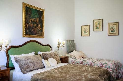 a bedroom with two beds and a painting on the wall at B&B CORSO VITTORIO in Venosa
