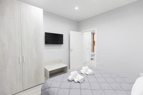a white bedroom with two white towels on a bed at B&B Chiaro di Luna in Barletta