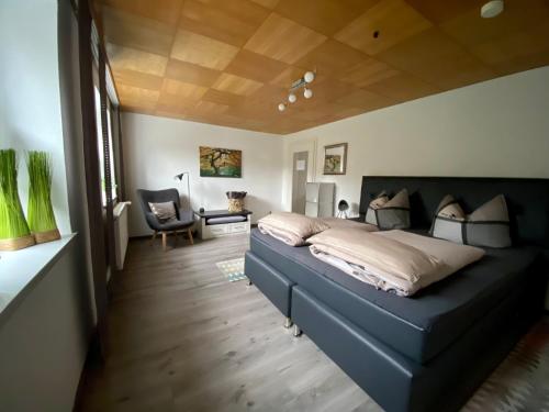 een slaapkamer met een groot bed en een stoel bij Ferienwohnung an der idyllischen Salzachschleife Nähe Salzburg in Laufen