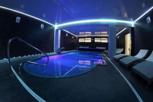a swimming pool in a room with blue lights at Penzión Aqua Maria in Veľaty