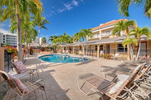 een resort met een zwembad, stoelen en palmbomen bij Walkable to Restaurants and Steps to the Beach! - Coconut Villa's Suite 10 in St Pete Beach