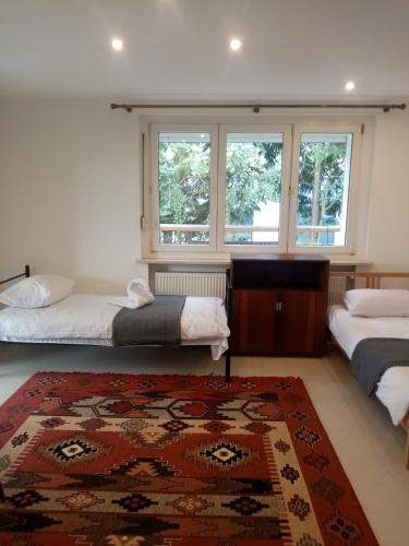 a bedroom with two beds and a rug at Willa u MARIANE in Przeźmierowo