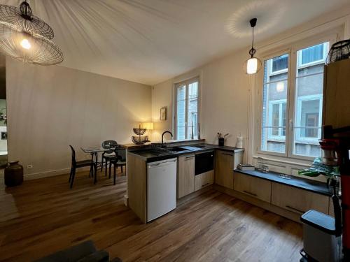 une cuisine avec un évier et une table à l'intérieur dans l'établissement Promenades / 1 Chambre / Neuf, à Roanne