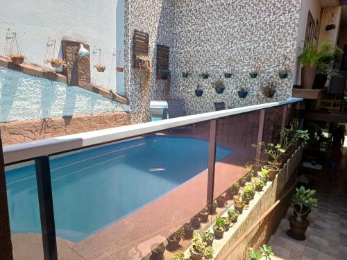 a swimming pool on a balcony with potted plants at Pousada Castro in Aparecida