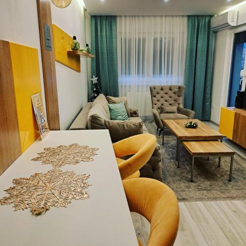 a living room with a table and a couch at Apartman Mosaic in Doboj