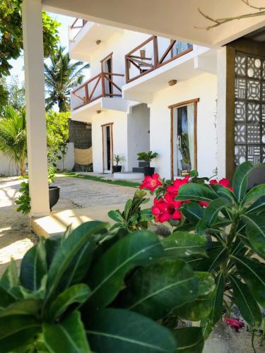 a house with red flowers in front of it at Vila Kitemania in Prea