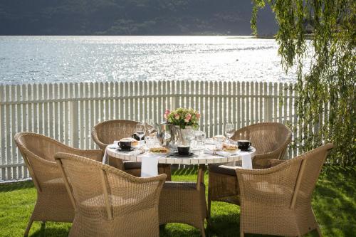 ein weißer Tisch mit Stühlen und ein Tisch mit Blumen darauf in der Unterkunft Hofslund Apartments in Sogndal