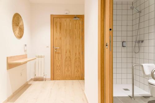 a bathroom with a toilet and a wooden door at APARTHOTEL SALBURUA in Vitoria-Gasteiz