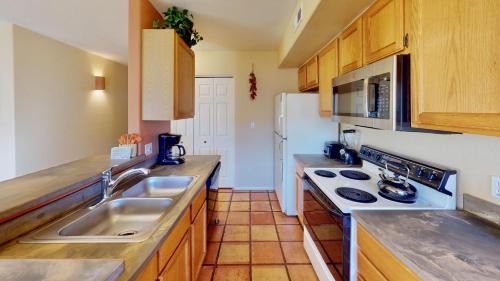 eine Küche mit einer Spüle und einem weißen Kühlschrank in der Unterkunft Kokopelli's Kiva #3230 in Moab