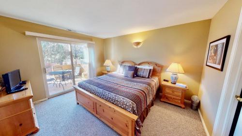 a bedroom with a bed and a window with a table at Kokopelli's Kiva #3230 in Moab