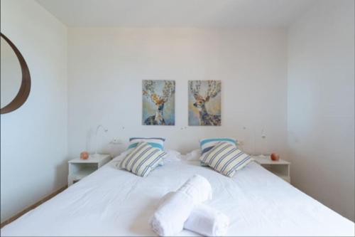 een slaapkamer met een wit bed met 2 kussens bij Fuerteventura Apartamento Costa Calma, Jandia in Costa Calma