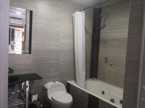 een badkamer met een toilet en een bad bij Miski Wasi Hospedaje Neiva in Neiva