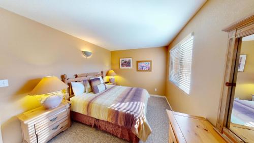 a bedroom with a bed and a dresser and a window at Kokopelli's Kiva #3230 in Moab