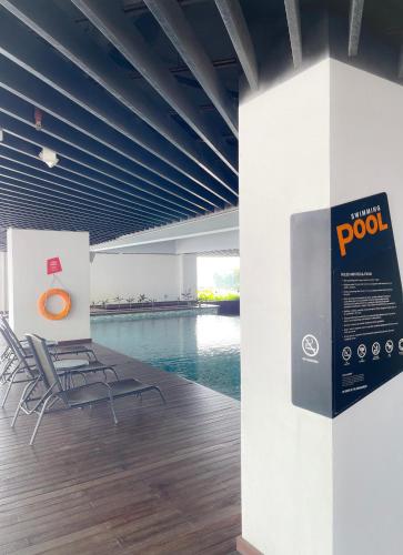 a group of chairs in a room with a pool at Atria SOFO Suites By Stay In in Petaling Jaya