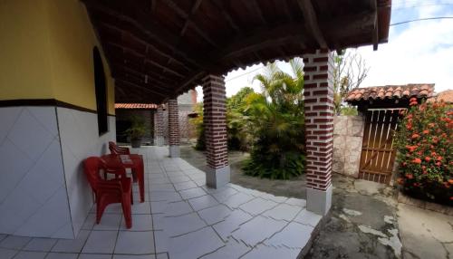 eine Terrasse mit Stühlen und einem Tisch auf einem Haus in der Unterkunft Casa de praia em ponta de areia - Raio do Sol House in Itaparica Town