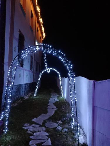 an arch with christmas lights on a building at night at Hostel Apollo in Ząbkowice Śląskie
