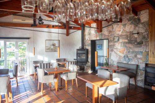 un restaurante con mesas y sillas y una pared de piedra en Casa Alta Hotel Boutique & Spa - Solo Adultos en Villa Carlos Paz