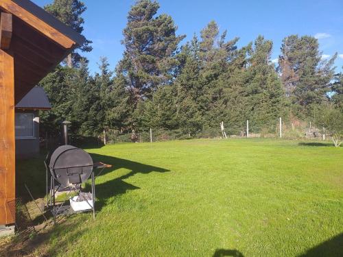 un patio con un gran campo de césped y árboles en Casa ideal para descansar a 20 min de Bariloche en Dina Huapi