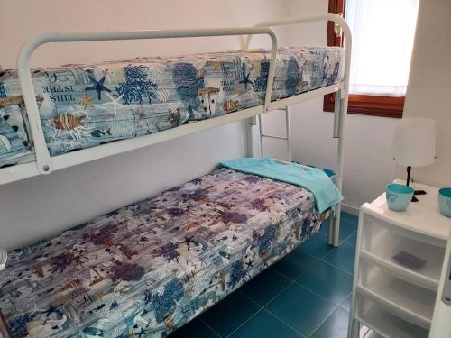 a bedroom with a bunk bed with a bedspread at SOLARE in Bibione