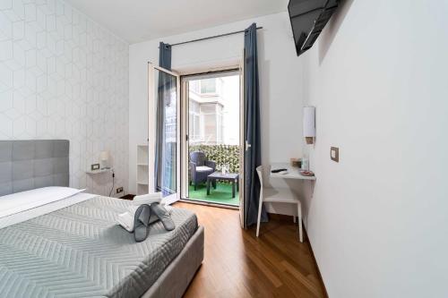 une chambre avec un lit, un bureau et une fenêtre dans l'établissement Dante 138 Class rooms & apartments, à Bari