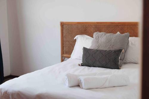 a white bed with two pillows on it at Sweet & Simple Beach Cottage in Jeffreys Bay