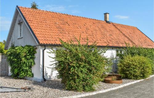 an orange roofed house with bushes next to a street at 2 Bedroom Beautiful Home In Smedstorp in Smedstorp