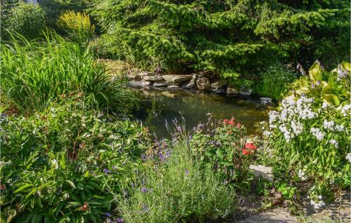 a pond in a garden with flowers and plants at 2 Bedroom Beautiful Home In Smedstorp in Smedstorp