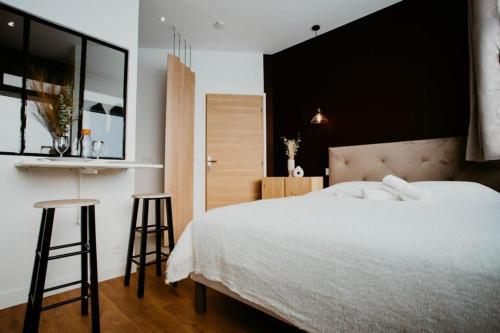 a bedroom with a white bed and two bar stools at Sweet Love Room - Jacuzzi Privatif in Montreuil