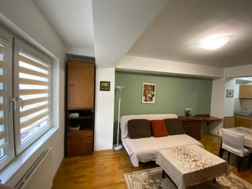 um quarto com uma cama, uma secretária e uma janela em apartment24 em Skopje