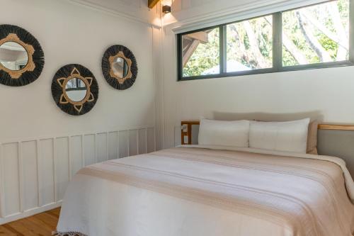 a bedroom with a bed and two wreaths on the wall at Blue Mist Hotel- Adults Only in Santa Teresa Beach