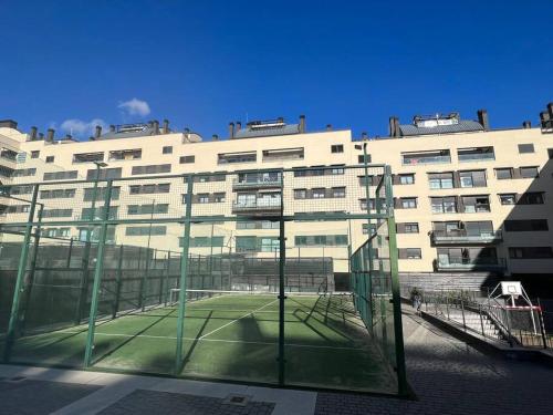 a tennis court in front of a large building at Apartamento cerca centro Madrid in Rivas-Vaciamadrid