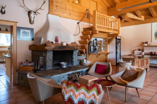 a living room with a stone fireplace and chairs at Sport-Lodge Klosters in Klosters