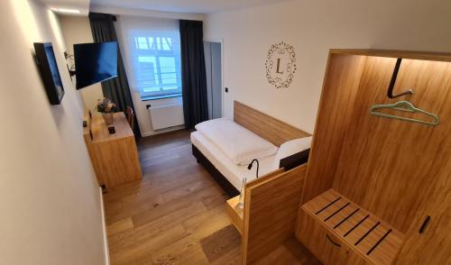 a small room with a bed and a window at Landgasthof zur Burg Grenzau in Höhr-Grenzhausen