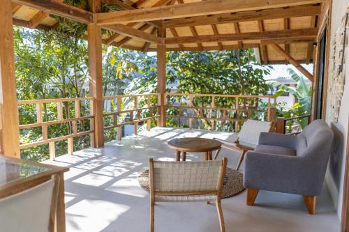 a porch with chairs and tables and a wooden roof at Blue Mist Hotel- Adults Only in Santa Teresa Beach