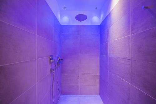 a purple bathroom with a shower with purple tiles at Hotel M&uuml;hlgarten in San Lorenzo di Sebato