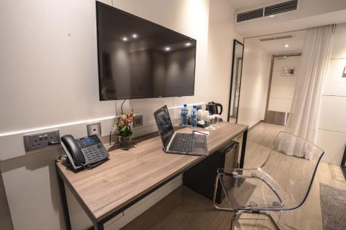 a room with a desk with two laptops and a television at Sarova Imperial Hotel in Kisumu