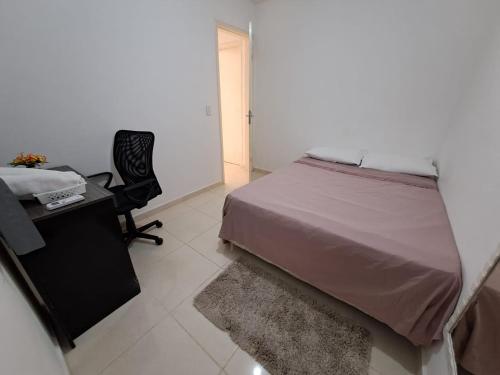 a bedroom with a bed and a desk and a chair at Maria Farinha casa in Maria Farinha
