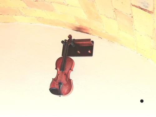 a violin is attached to a brick wall at Trastevere in Music in Rome