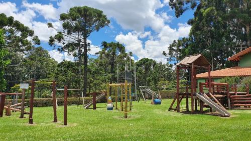 um playground com equipamentos de madeira em um parque em Cachoeira dos Luis - Parque & Pousada em Bueno Brandão