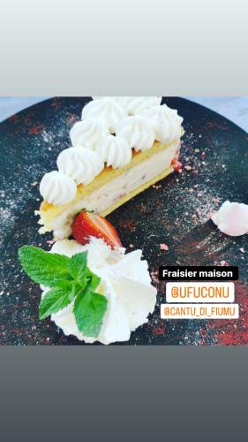 a piece of cake with whipped cream and a strawberry at Cantu di Fiumu in Zonza