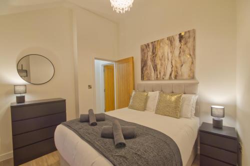 1 dormitorio con 1 cama con 2 toallas marrones en Harbour Heights, Luxury Coastal Apartment in The English Riviera, close to the Shops, Bars, Restaurants, Marina and Beaches, en Torquay