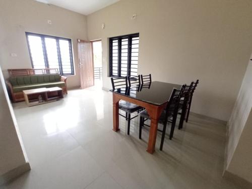 a dining room with a table and chairs at Eve's Residency in Meppādi