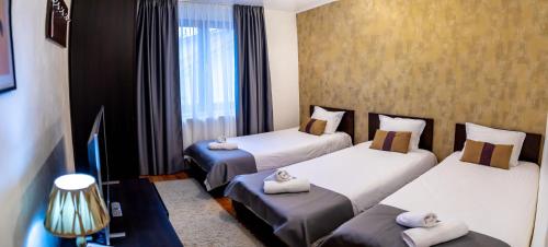 a hotel room with three beds and a fireplace at Velinov Boutique Hotel in Bansko