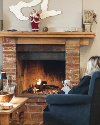 a woman sitting in a chair in front of a fireplace at Sea View Villa with 4 bedrooms - grECOrama in Monodhéndrion