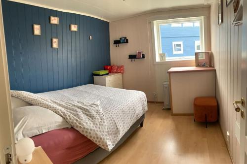 een kleine slaapkamer met een bed en een raam bij Cosy house with sunny terrace, garden and fjord view in Bergen