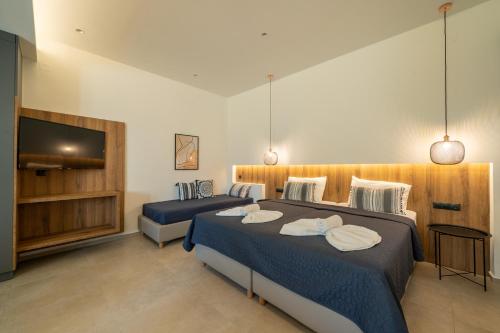 1 Schlafzimmer mit 2 Betten und einem Flachbild-TV in der Unterkunft Esperos Studios and Apartments, #2 in Stalida