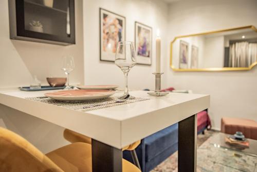 a table with a wine glass and a candle on it at Artemis Apartment Midas Home Project in Thessaloniki