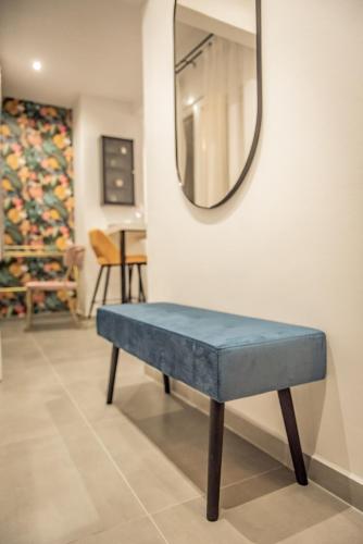 a blue bench sitting in front of a mirror at Artemis Apartment Midas Home Project in Thessaloniki